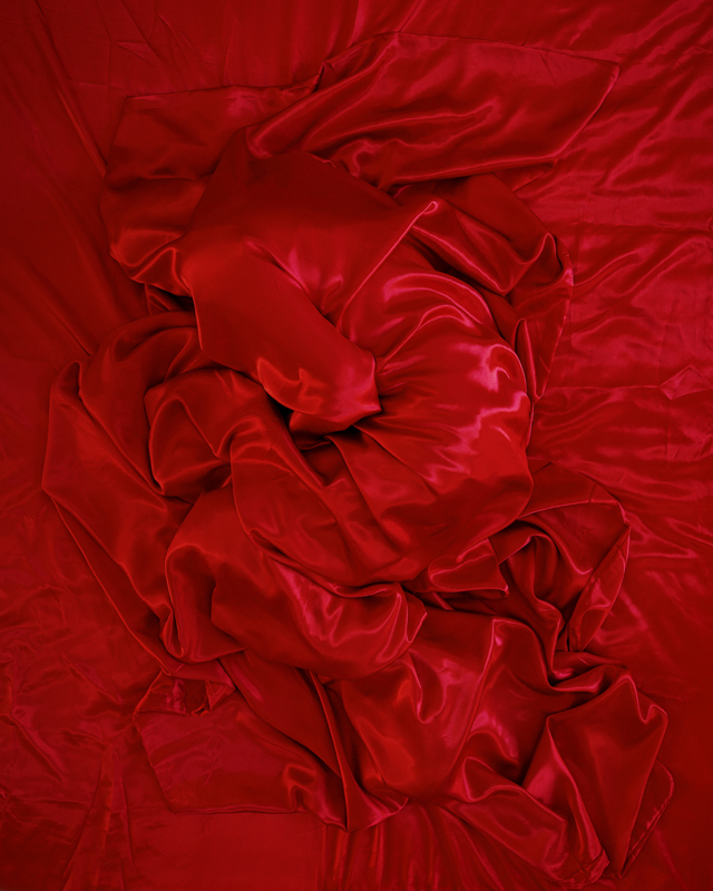 Person covered by a red sheet, embodying an emotion for installation